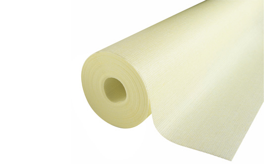 Krämfärgad non-woven tapetrulle med vävd struktur delvis utrullad på vit bakgrund