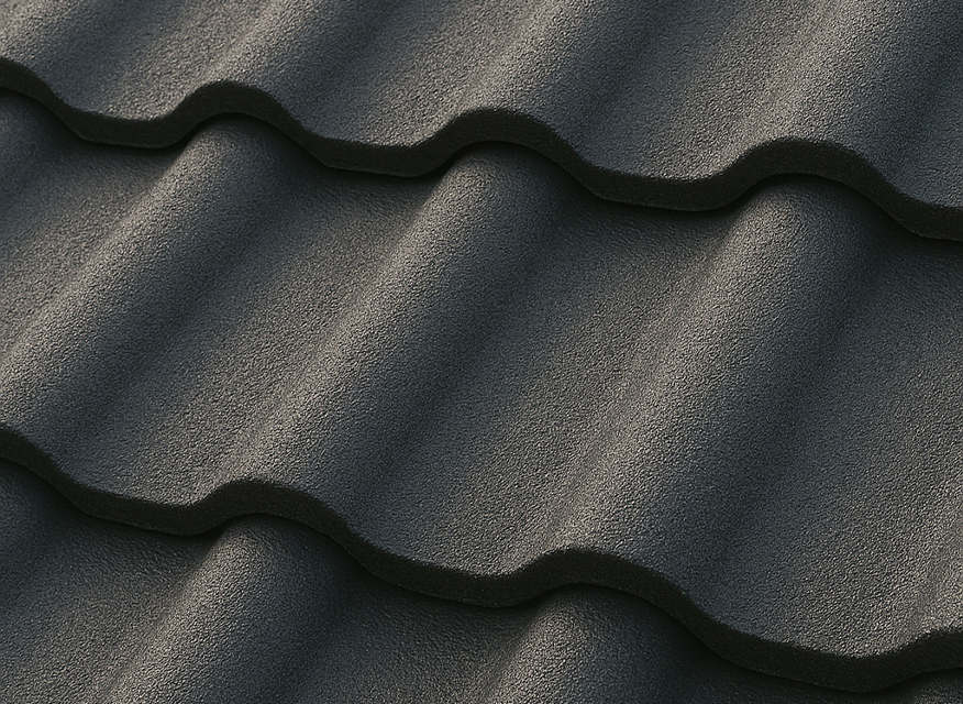 En närbild av ett mörkfärgat takmaterial med vågig struktur. Ytan består av överlappande takpannor eller plåtar i ett jämnt och återkommande mönster.