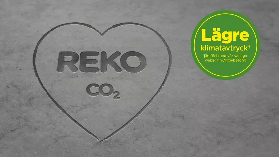 Grå betongyta med inristat hjärta ‘REKO CO₂’ och grön-gul badge ‘Lägre klimatavtryck’