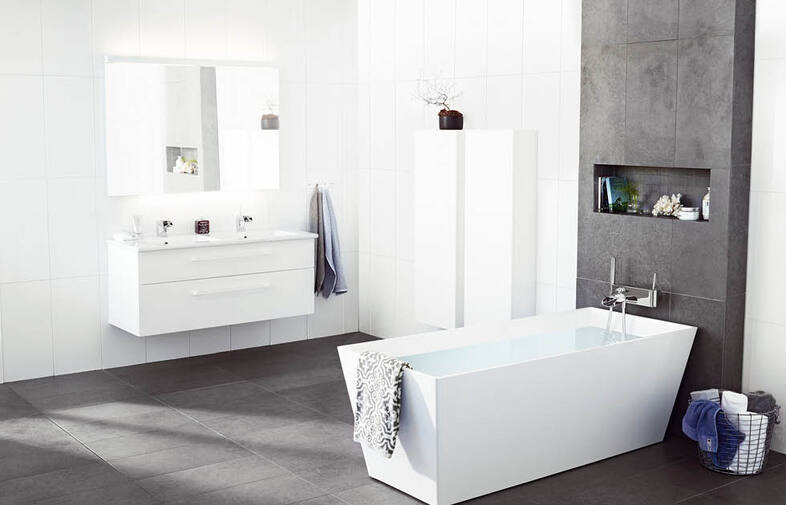 Modernt vitt badrum med fristående rektangulärt badkar på mörkgrått klinkergolv och dubbla handfat