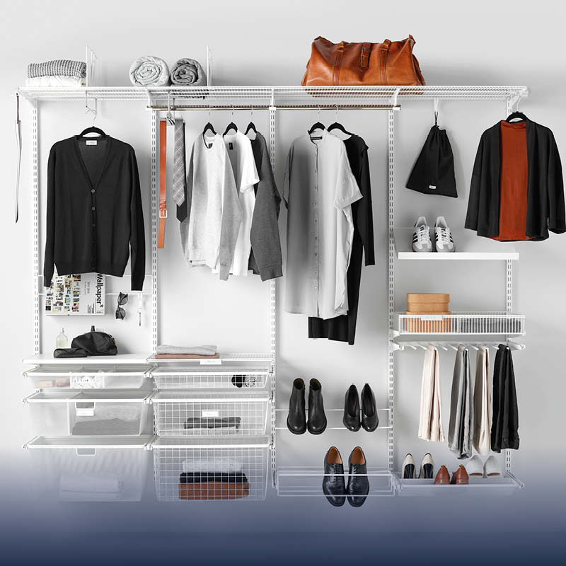 Öppet vitt garderobssystem med hängande svart, grått och vitt plagg, skor, brun väska, lådor