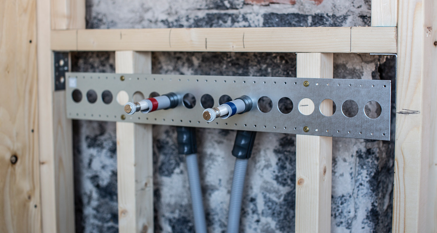 Där efter lade vi in rör för vatten, el och avlopp. Utanpå reglarna satte vi upp plywood och därefter gipsskivor. 