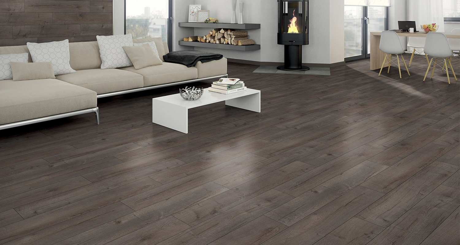 Mörkt trägolv i vardagsrum med inredning och öppen spis