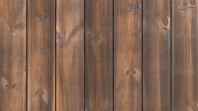 Vertikala släta bruna träpaneler med tydlig ådring och knutmärken