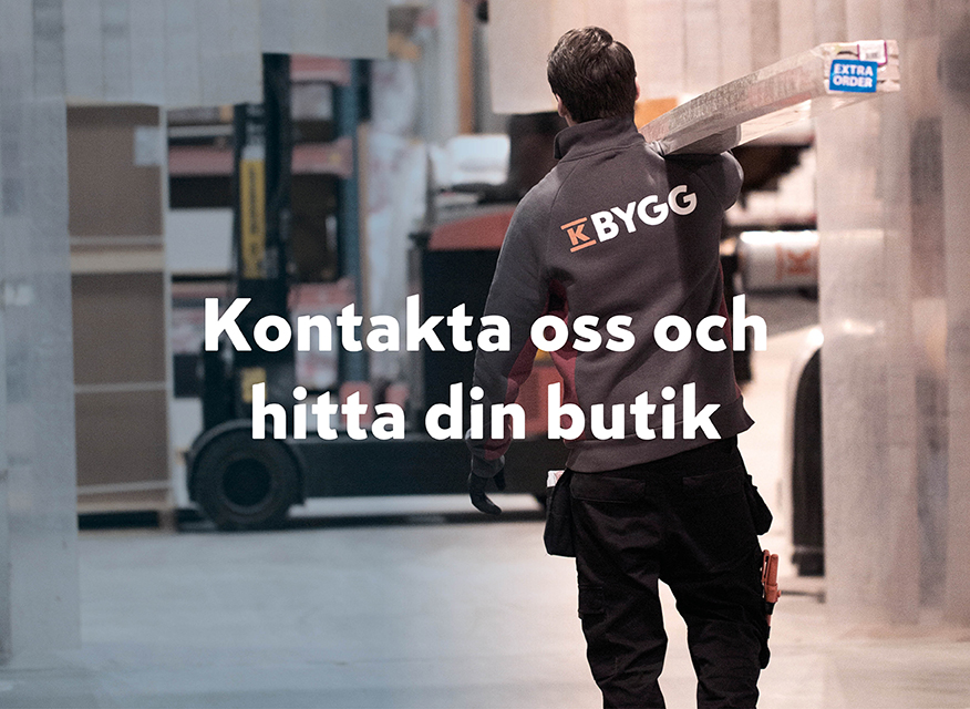 en person med en jacka där det står "K-BYGG" på ryggen, som bär en träplanka i en butik eller lager. I mitten finns texten: "Kontakta oss och hitta din butik".