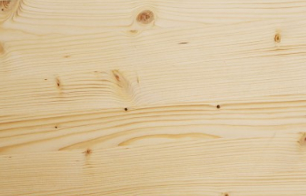 Närbild av obehandlad ljus träplanka med synliga ådror och kvistar.