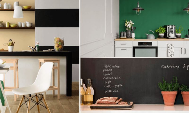 Modernt kök med svartvita ränder, grön fondvägg, barbord, öppna hyllor med porslin och örter.