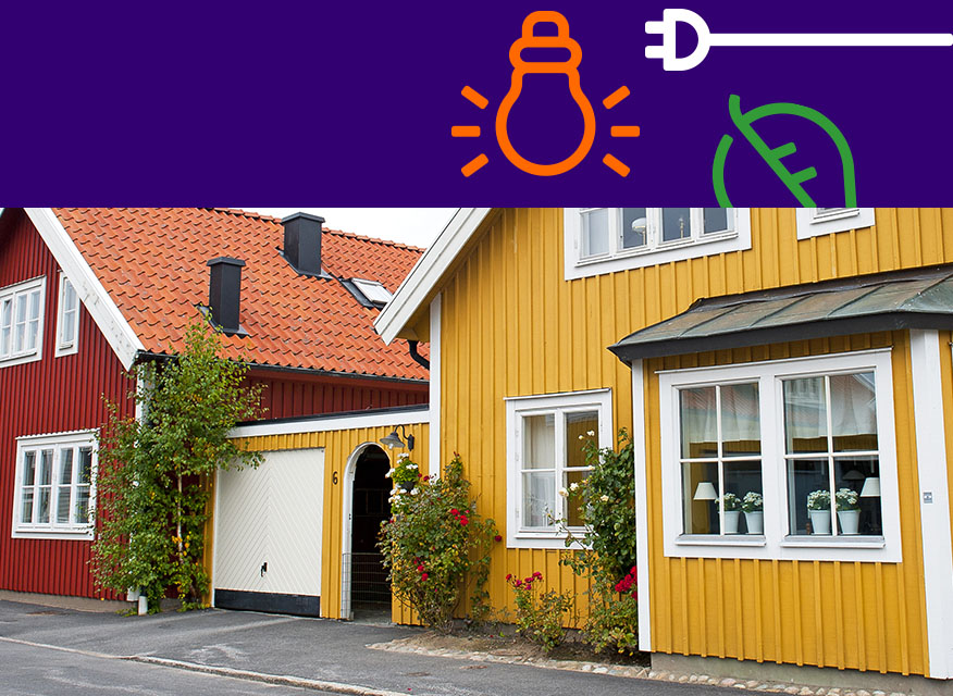 En gul och en röd trästuga med vita fönster, tegeltak och rosbuskar utanför.