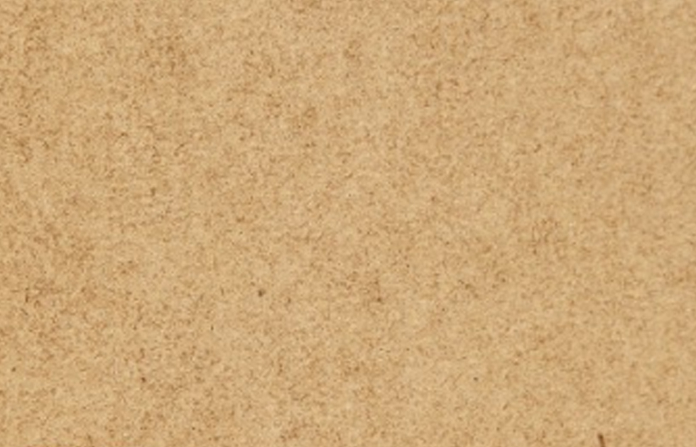 Närbild av kornig beige korkyta med små mörka fläckar.