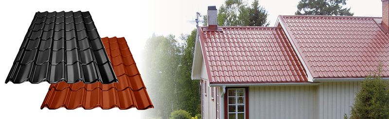 Röda och svarta plåttakspaneler bredvid ett hus med rött plåttak och beige fasad i skogsmiljö