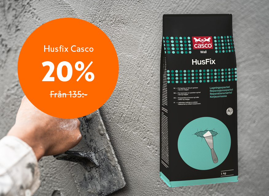 Hand spacklar grå vägg med svart Casco HusFix-påse, turkosa prickar och orange 20% rabattmärke.