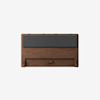 A wooden headboard with a rectangular shape, featuring a dark gray cushioned panel across the top and a simple, minimalist design. The wood has a smooth finish and warm brown tone.
