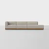 A modern, light beige sectional sofa with three connected seats, including a left-arm corner and a right-arm chaise lounge, all set on a low wooden base against a plain white background.