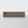 A modern, three-seater brown sofa with clean lines and a wooden base sits on a light gray floor against a plain white background.