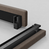 Two sections of a bed frame with brown upholstered sides and exposed black metal connectors are positioned on a light surface, ready to be attached together.