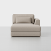 A modern beige upholstered chaise lounge with a rectangular backrest cushion and a single right armrest, set against a plain white background.