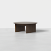 A modern, round wooden coffee table with a flat top and three thick, rectangular legs, set against a plain white background.