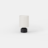 Small cylindrical table lamp with a dark base and a light-colored drum shade.