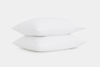 Two white pillows stacked on top of each other against a plain white background.