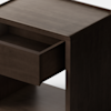 A dark wooden cabinet with short legs is shown against a plain white background. One drawer on the left side of the cabinet is pulled open, revealing an empty interior.