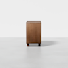 A rectangular wooden cabinet with a simple, minimalist design stands on short cylindrical legs against a plain white background.