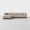 A modern, L-shaped sectional sofa with light beige upholstery and a dark wooden base, placed on a smooth white floor against a plain white background.