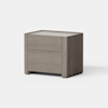 A modern, light brown wooden nightstand with two drawers, simple lines, and a smooth finish, placed on a light gray surface against a plain white background.