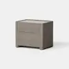 A modern, light brown wooden nightstand with two drawers, simple lines, and a smooth finish, placed on a light gray surface against a plain white background.
