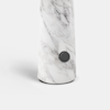 A close-up of a marble cylinder with a dark gray knob on its side.