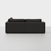A modern, dark gray sectional sofa viewed from the back, set against a plain white background. The sofa has clean lines and thick cushions, with no visible legs.
