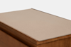 A minimalist wooden box with a flat, light beige lid or panel on top, shown at an angle against a plain white background.