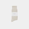 A single pair of light beige ribbed socks, neatly folded and wrapped with a white paper band labeled THUMA, is displayed against a plain white background.