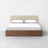 A modern bed with a light beige upholstered headboard, white bedding, two pillows, and a wooden frame, set against a plain white wall on a light gray floor.