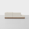 A modern, light beige sectional sofa with clean lines, low backrests, and a wooden base, shown from the side against a plain white background.