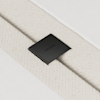 A close-up of a textured beige fabric strap secured by a black metal clasp with the word THUMA engraved on it, set against a white background.