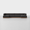 A modern, low-profile sectional sofa with dark gray upholstery and wooden base, arranged in an L-shape on a light, spacious floor with a plain white background.