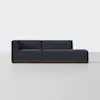 A modern dark blue sectional sofa with a left armrest and chaise lounge on the right, set on a low wooden base against a plain light gray background.