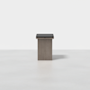 A minimalist, square, wooden pedestal or side table with a dark top and a light gray base, set against a plain white background.