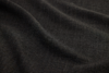 Close-up of dark, textured fabric with visible weave pattern and gentle folds, creating soft shadows.