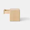 A plain, light wood square box with smooth edges sits on a pale gray surface against a white background.