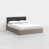 A modern bed with a light wood frame and a dark upholstered headboard, dressed in white bedding and pillows, placed in a minimalistic room with white walls and floor.