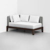 A modern daybed with a dark wooden frame, gray upholstered backrest, and three white pillows, positioned against the corner of a white room with a light gray floor.