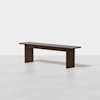 A minimalist, dark wooden bench with clean lines and thick rectangular legs, set against a plain white background.