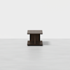 A dark wooden square coffee table with a thick top and base, featuring a central support, placed on a light, plain background.