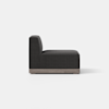 A modern armless black upholstered chair with a tall backrest and cushioned seat, set on a light wooden base, shown in profile against a plain white background.