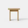 A simple, light wood table with a rectangular top and three legs, photographed against a plain white background.