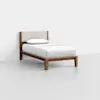 A single bed with a wooden frame, white bedding, a white pillow, and a beige upholstered headboard, positioned against a plain white wall on a light gray floor.