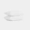 Two plain white pillows are stacked on top of each other against a simple white background.