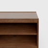 A close-up of a wooden shelf unit with a rectangular shape, featuring a smooth surface and an open middle shelf, against a plain white background.