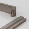 Two pieces of light brown wood with interlocking joints are arranged on a light surface, illustrating a precise woodworking connection, possibly for furniture assembly.